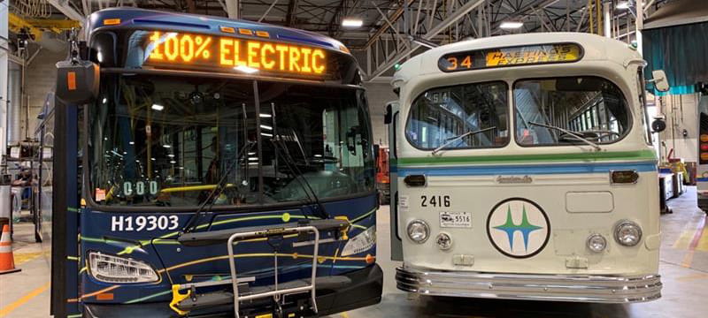 An electric bus parked next to a retro TransLink bus