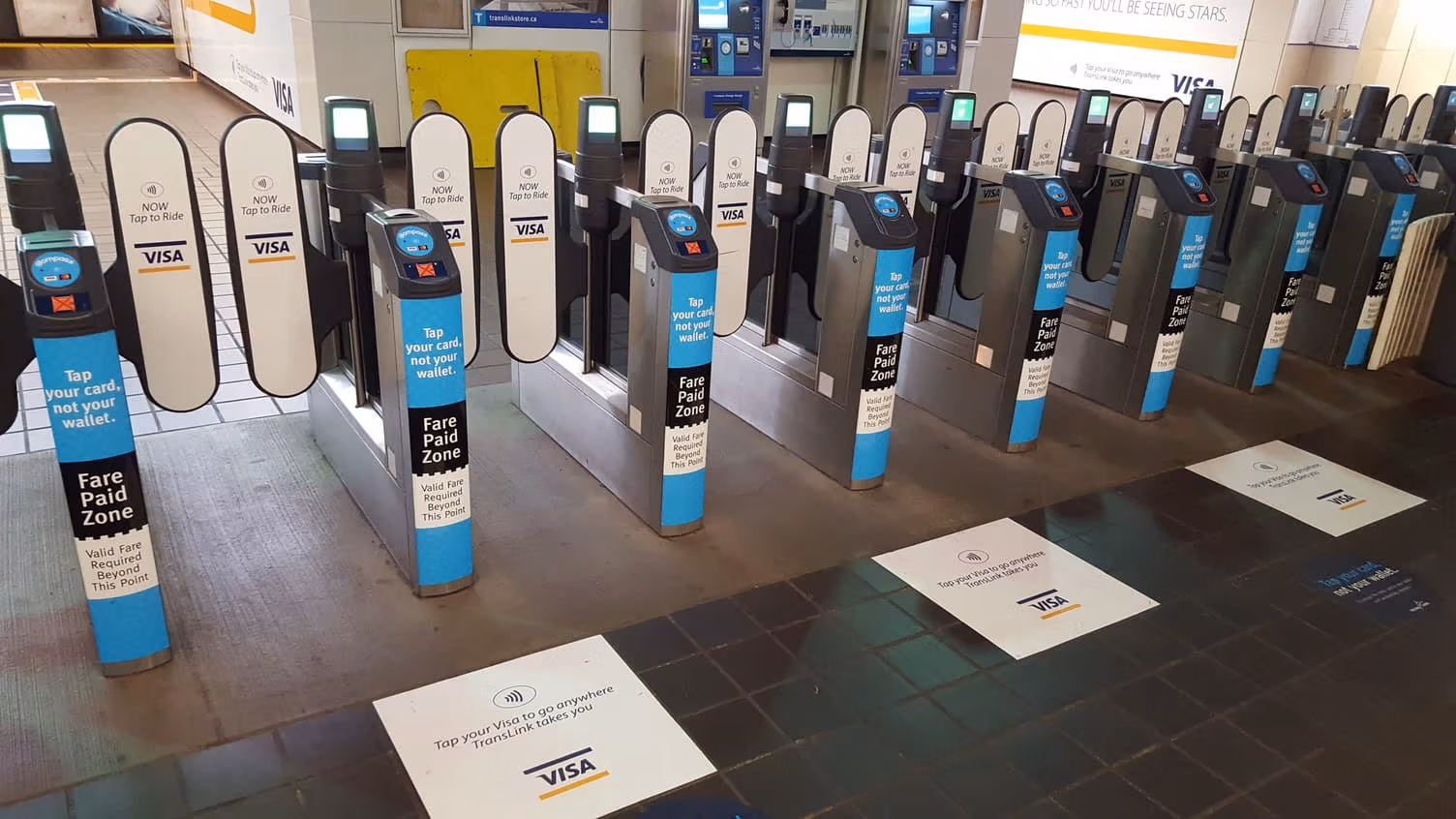 Closed fare gates displaying signs promoting Tap to Pay