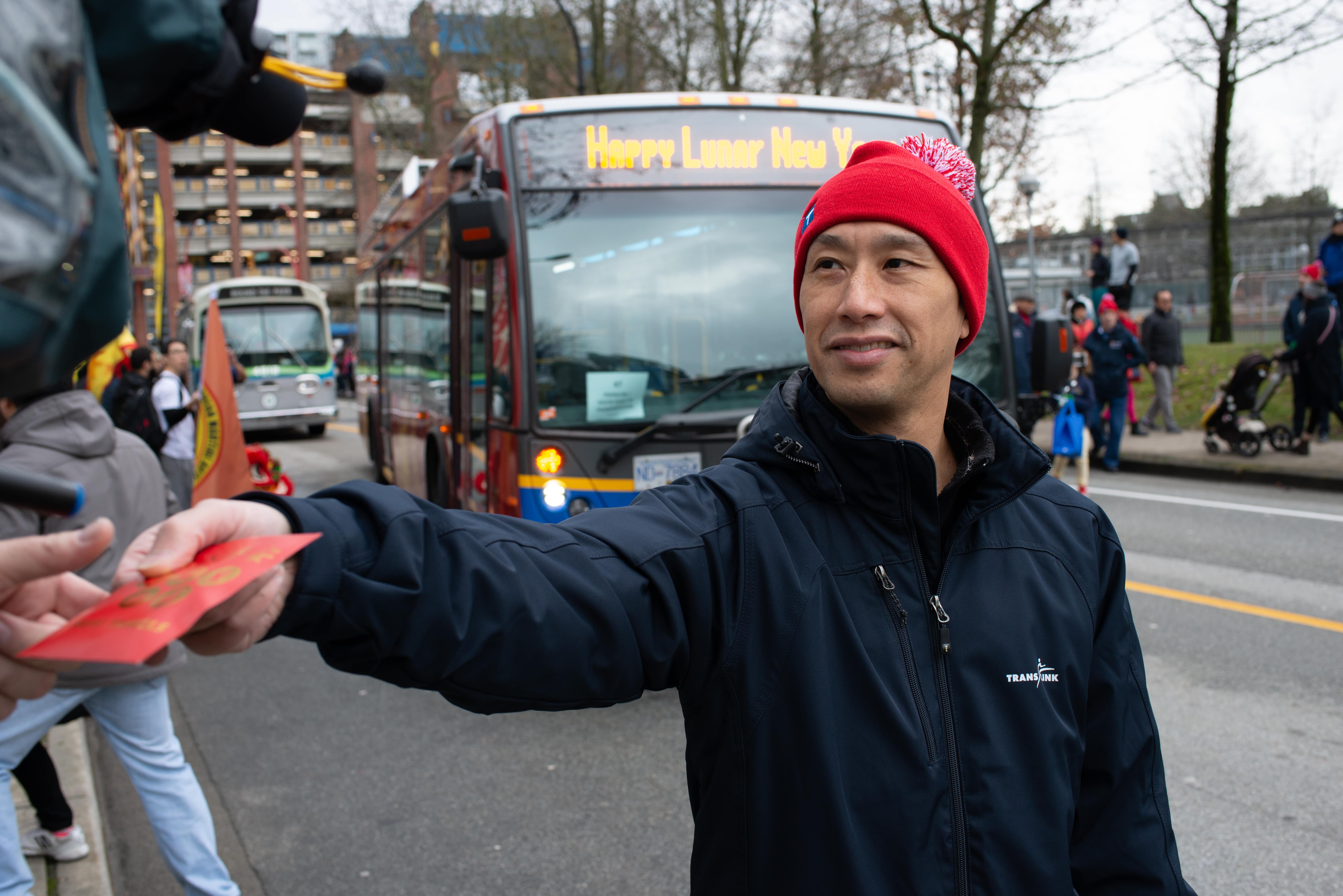 A TransLink representative handing out red packets to people on the street