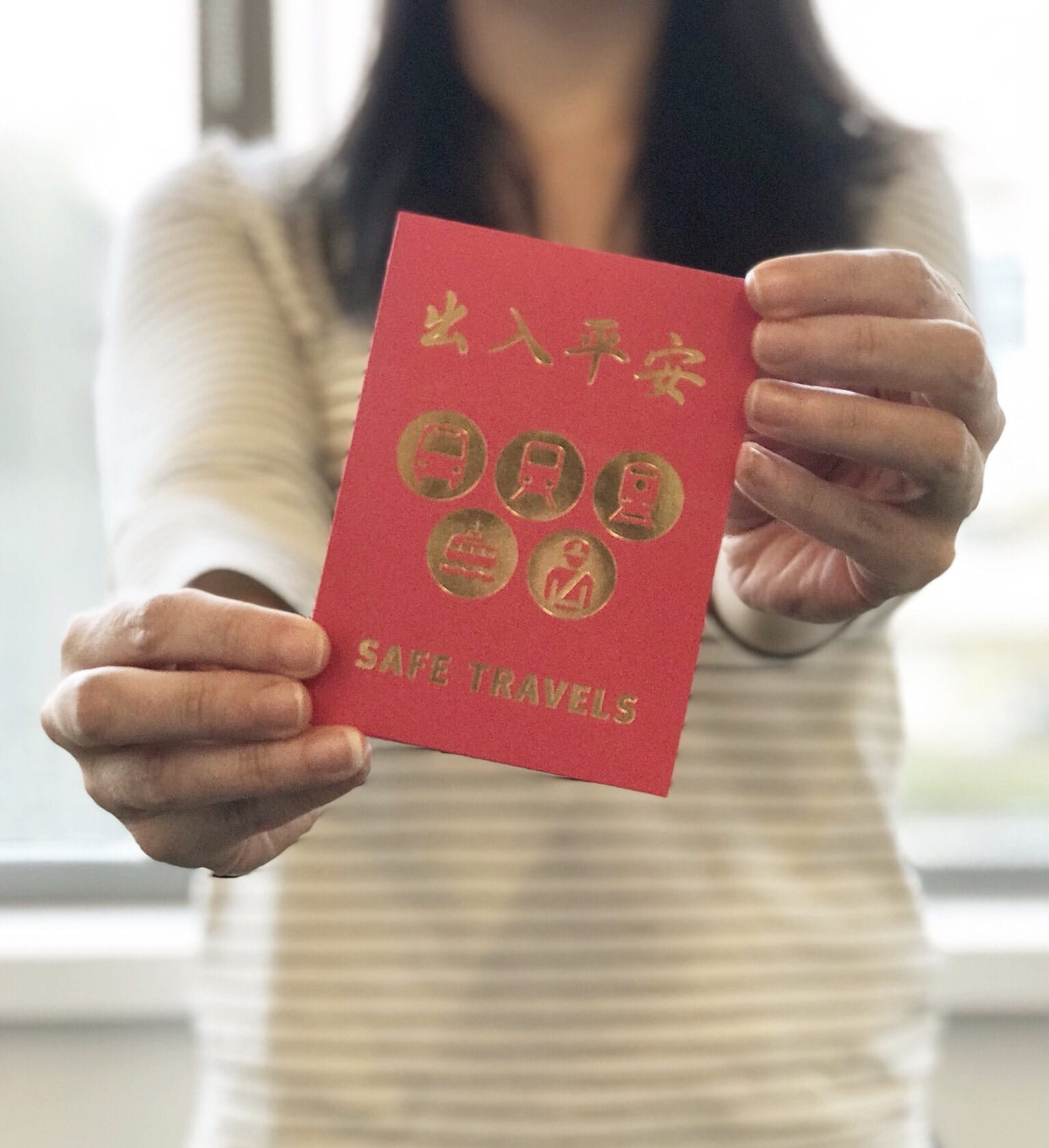 A woman holding up a red Lunar New Years packet