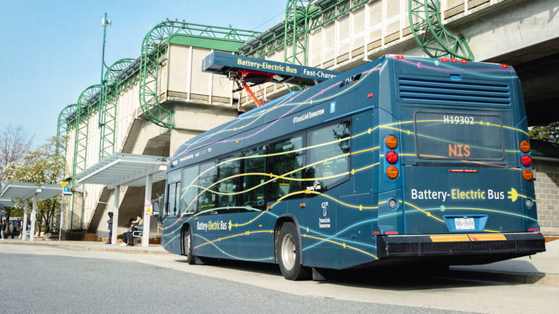 Rear view of an electric battery bus charging at an Expo LIne SkyTrain station