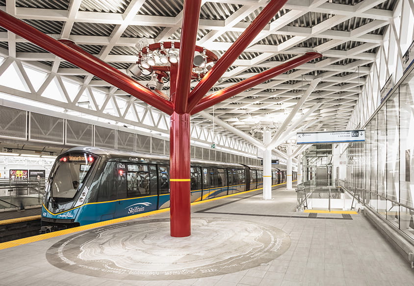 A bus driving past a bus stop in front of a forest