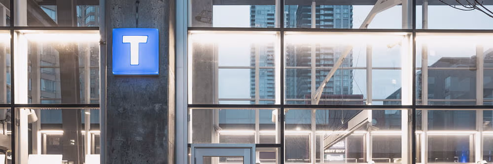 The TransLink T sign illuminated at a SkyTrain station