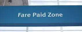 A sign that says fare paid zone