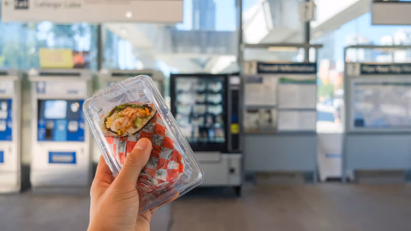 A sushi wrap in front of a vending machine at Lafarge Lake–Douglas Station