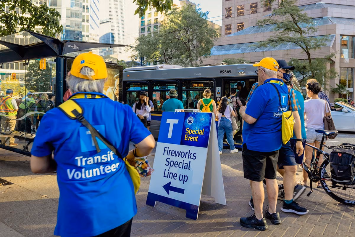 Volunteers helping crowds board a bus during the Celebration of Light