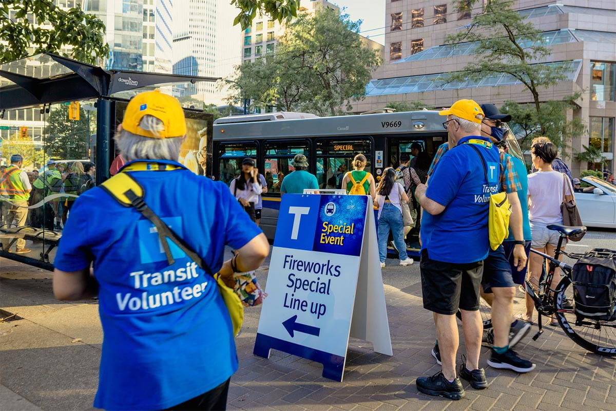 Volunteers helping crowds board a bus during the Celebration of Light