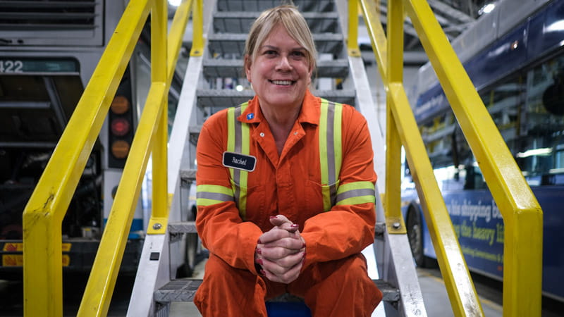 CMBC mechanic smiling while sitting on stairs
