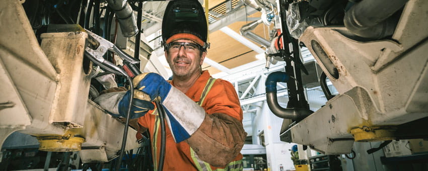 CMBC Autbody mechanic working underneath vehicle