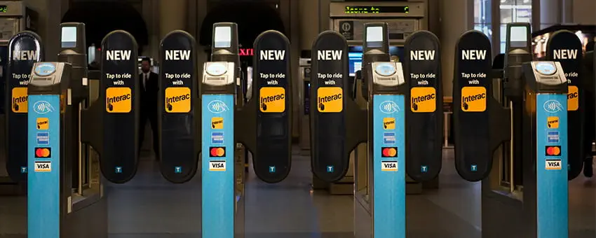 Interac Debit decals on Compass fare gates at a SkyTrain station