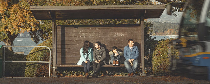 Family waiting at a bus shelter