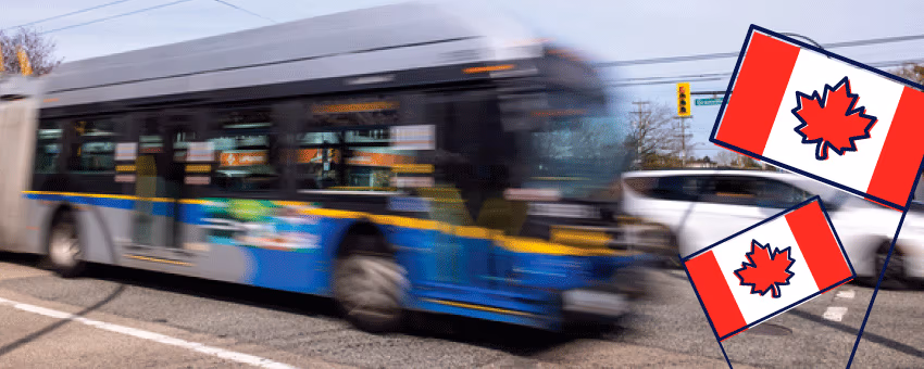 A blurred TransLink bus drives past on a city street, with two illustrated Canadian flags in the foreground, suggesting a Canada Day theme.