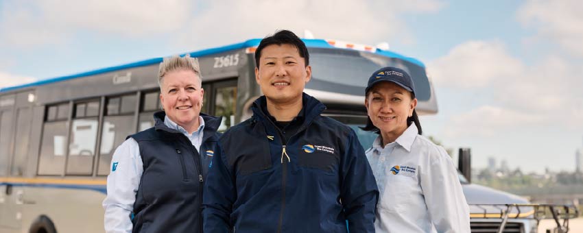 Three bus operators in front of a bus