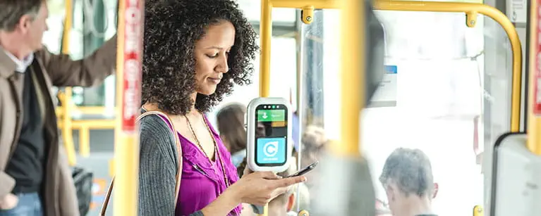Woman using her mobile devices on a bus