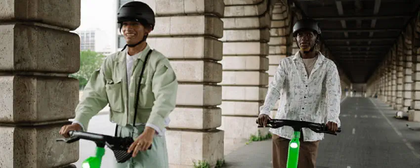 Two passengers riding e-scooters