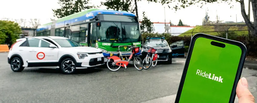 A person holding a mobile phone with the RideLink app open in the foreground, a Modo vehicle, RapidBus, Mobi Bikes and Evo vehicle displayed in the background