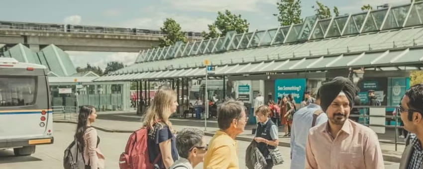 Passengers at the Surrey Central bus loop on a summer day