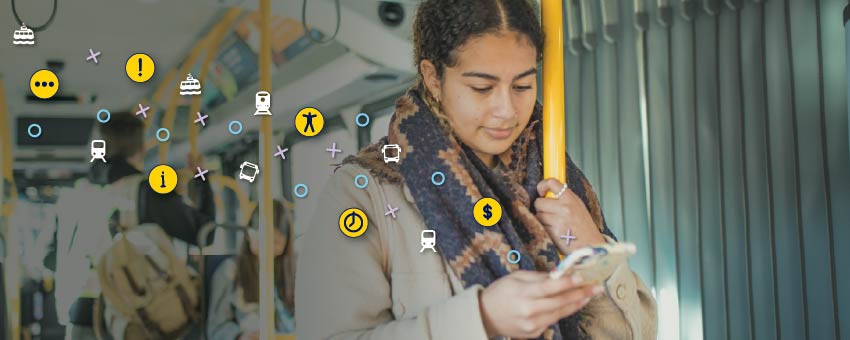 A passenger standing while commuting on the bus, looking at her phone, with yellow, teal, and white bus, SeaBus, and SkyTrain icons floating above the image.
