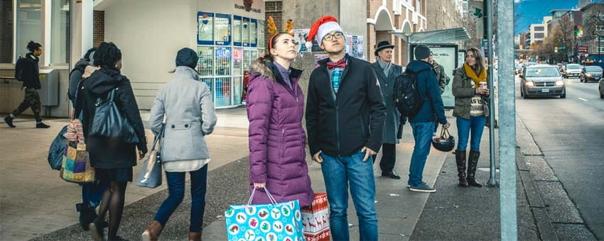 A young couple with shopping bags waiting for the #19 bus to Metrotown