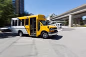A HandyDart van driving near a SkyTrain station