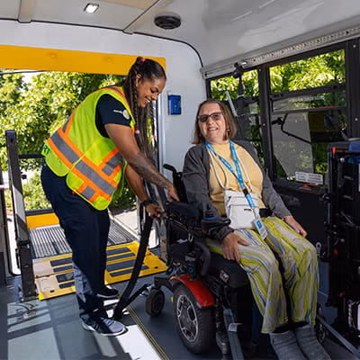 Driver securing a wheelchair inside a HandyDART