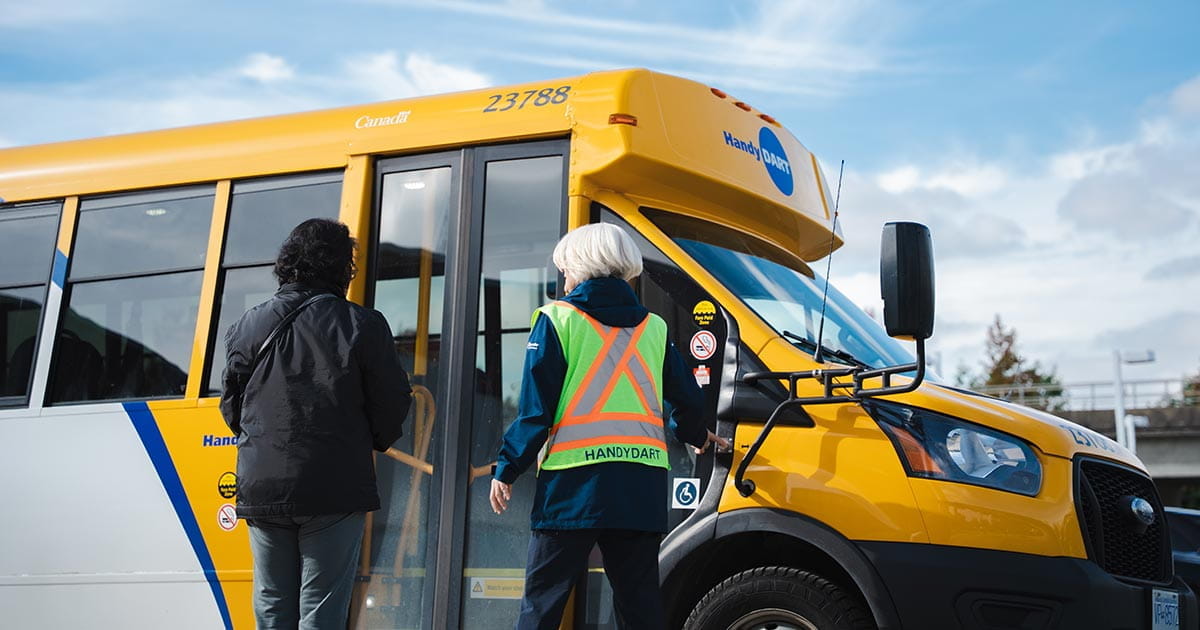 A driver assisting a passenger boarding a HandyDART