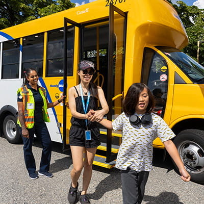 Passengers stepping off a HandyDART with driver support