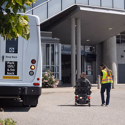 HandyDART driver assisting a passenger arriving at SkyTrain station