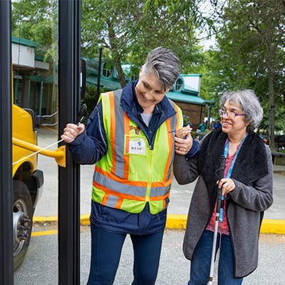 Driver assisting a passenger enter a HandyDART