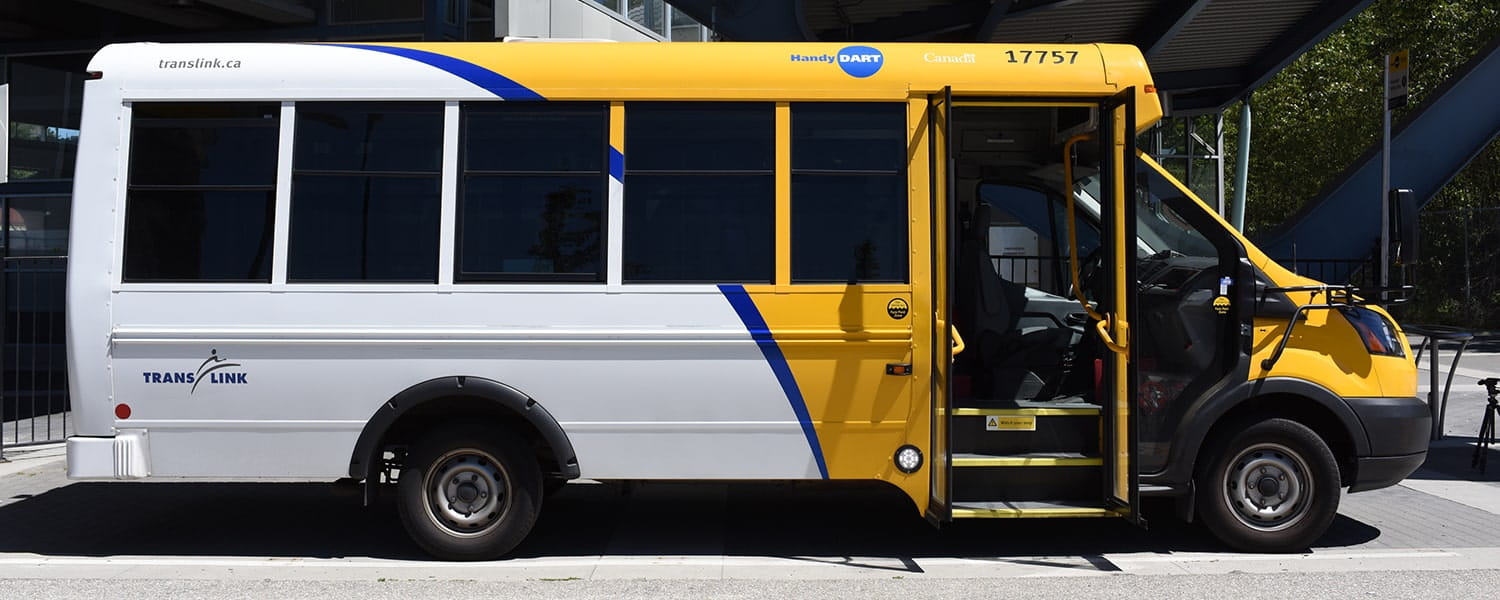 A HandyDART shuttle bus parked outside with the front door swung open
