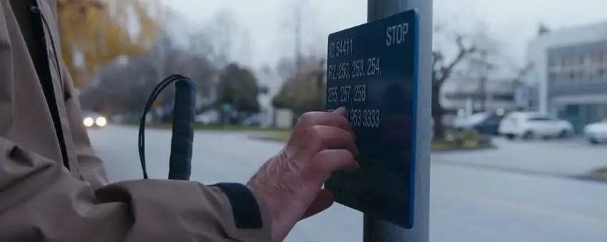 A blind man reading a tactile bus stop sign