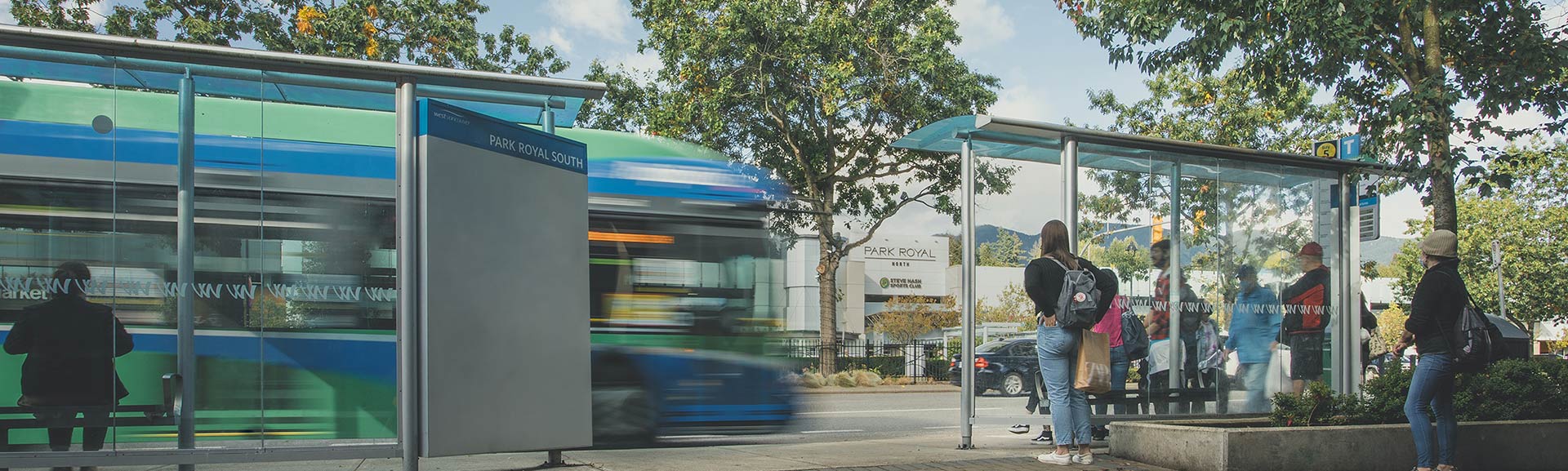 a RapidBus stopping to pick up people at a bustling bus exchange in North Vancouver