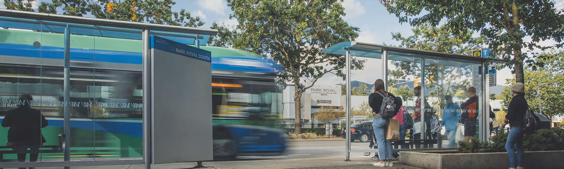 a RapidBus stopping to pick up people at a bustling bus exchange in North Vancouver