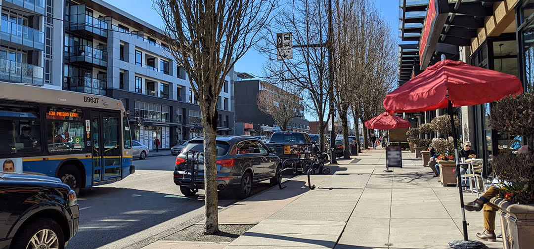 A RapidBus stopping at a bus stop with people about to board. The bus has a head sign spelling out Hastings Street