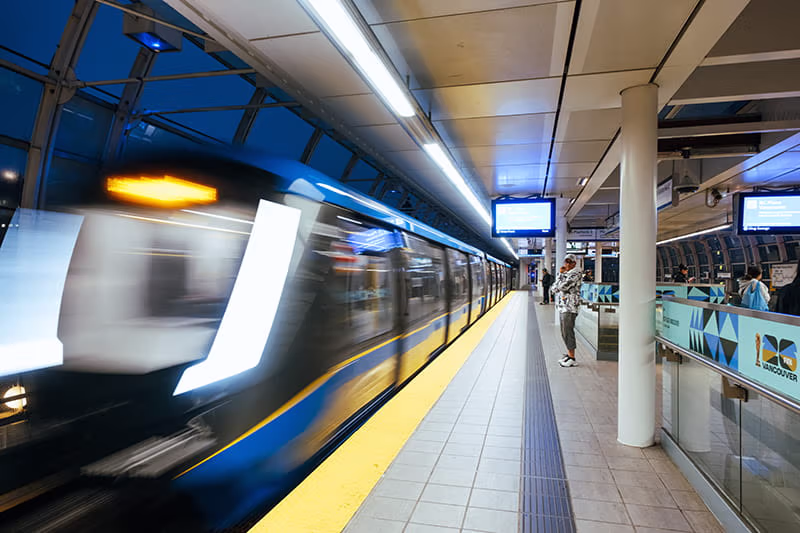 Main Street–Science World Station platform at night. A Mark V SkyTrain is arriving at the station.