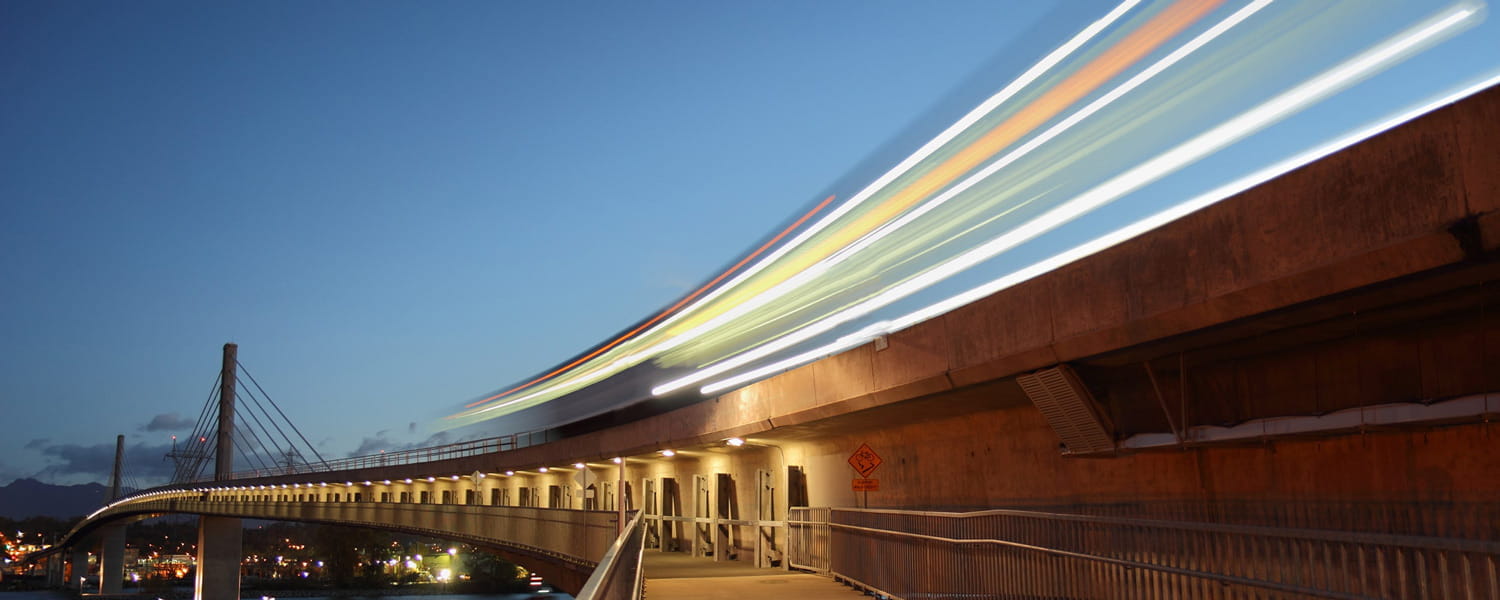 A SkyTrain running on rail against a clear evening sky