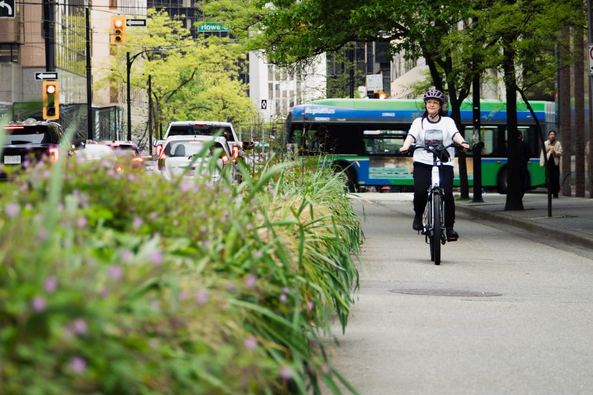 A woman riding a bike in a separated bike lane in downtown Vancouver