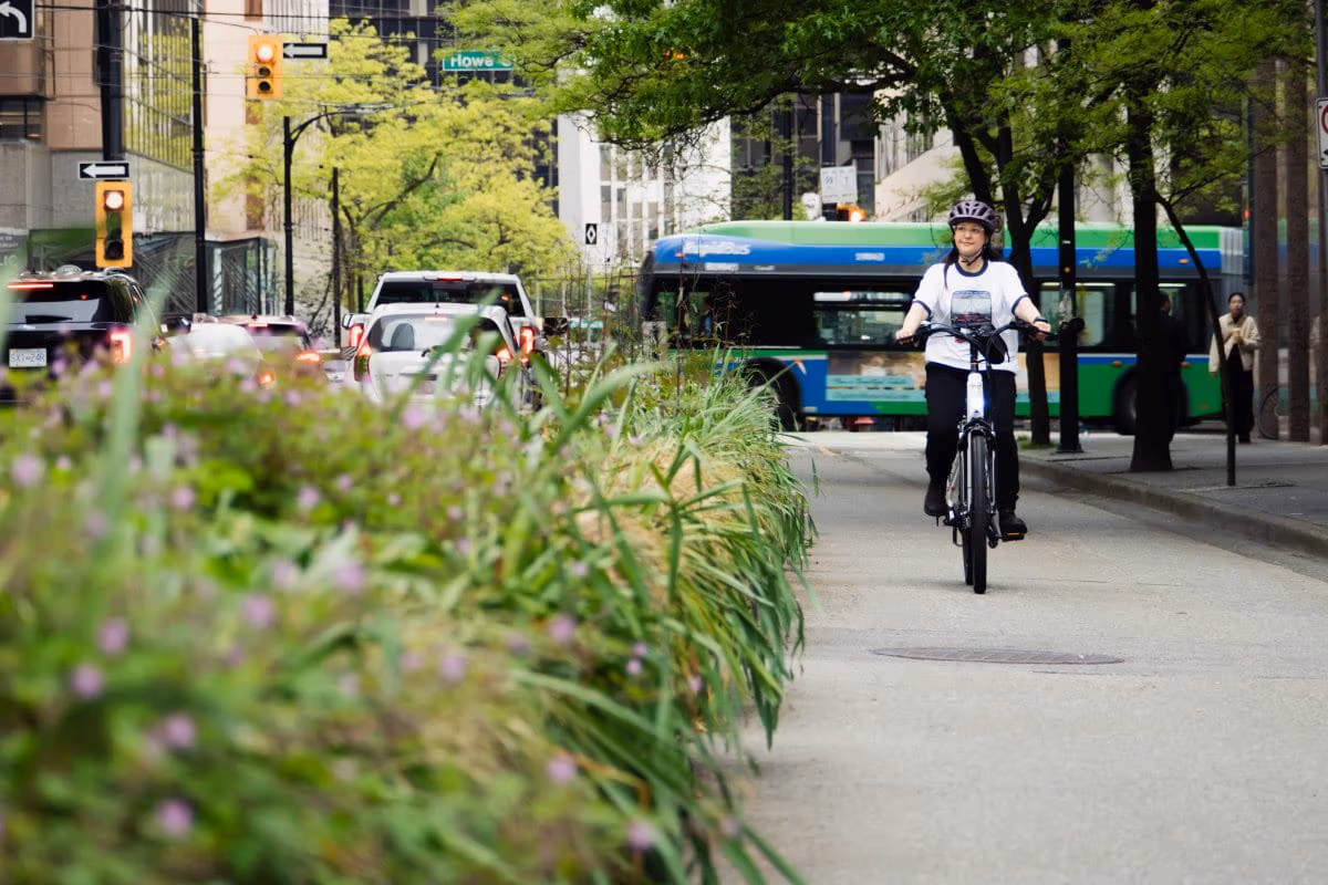 A woman riding a bike in a separated bike lane in downtown Vancouver