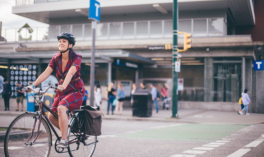 A woman crossing the street on her bike in Metro Vancouver