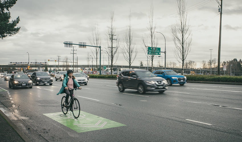 A woman crossing the street on her bike in Metro Vancouver