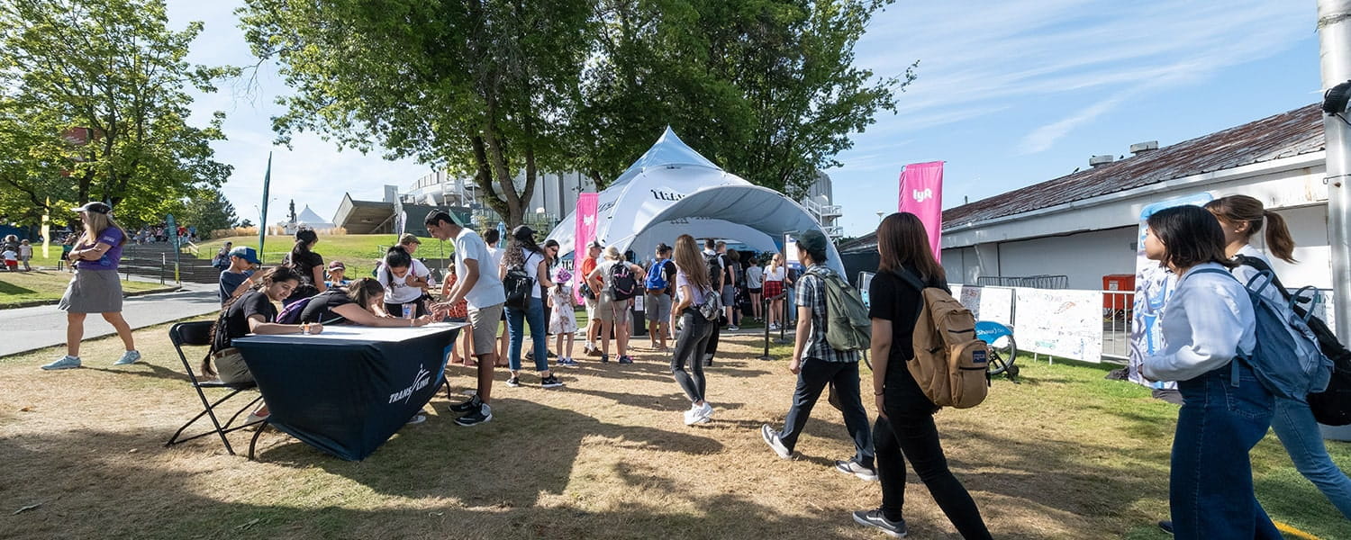 People engaging with TransLink staff at an outdoor fair