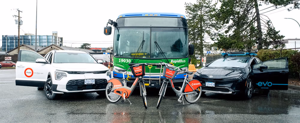 A modo car, RapidBus, Evo car and two Mobi bikes, posed in the rain