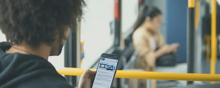 A passenger checks the U-Pass website on their mobile device while on the bus