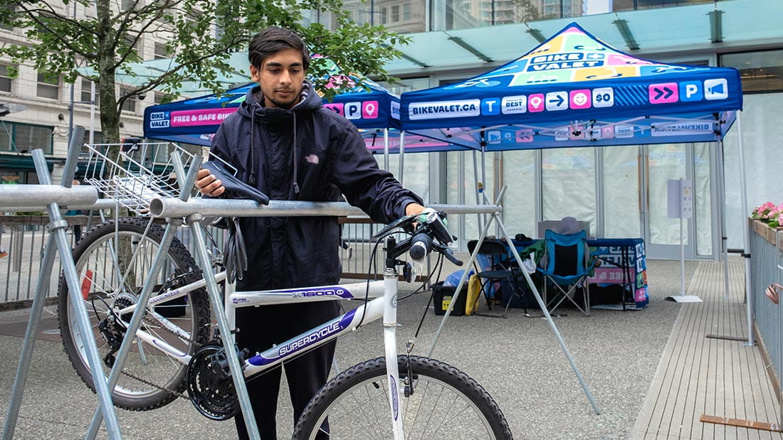 A cyclist leaving their bike at the Bike Valet location
