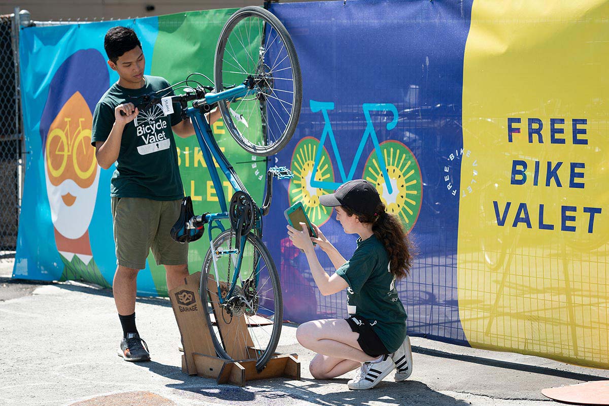 Two bike valet employees putting garage 529 stickers on a bike