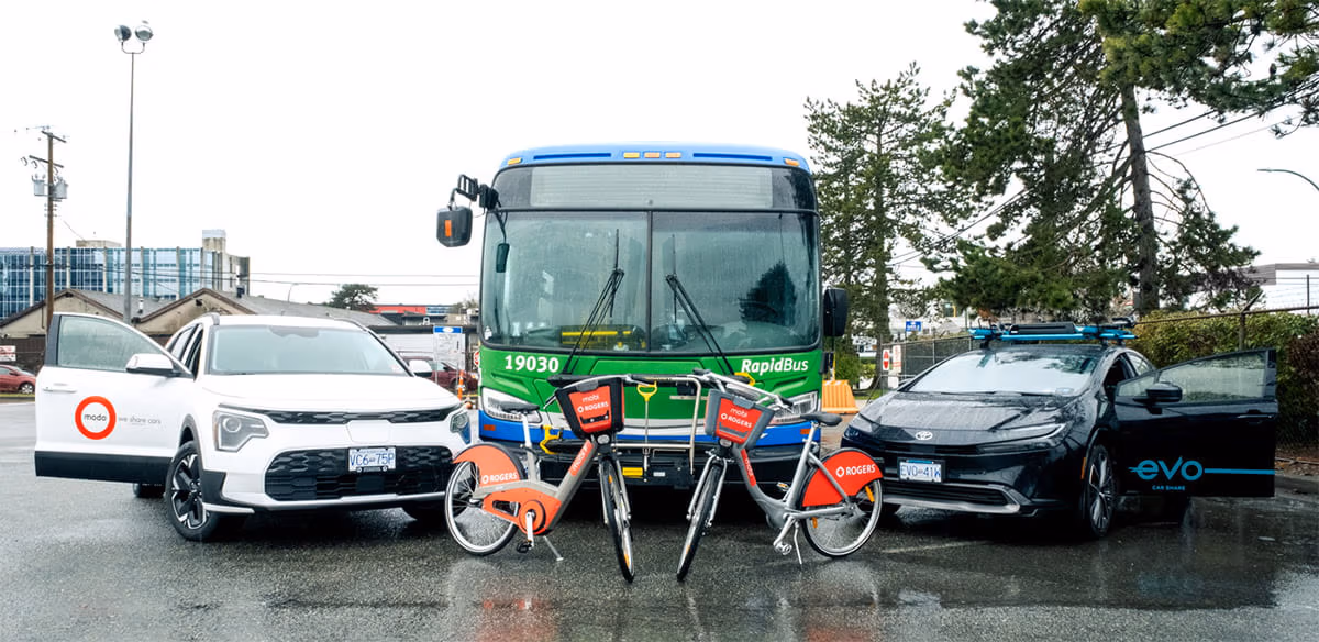 An Evo vehicle, Mobi e-bike and Modo vehicle, parked in front of a green RapidBus.