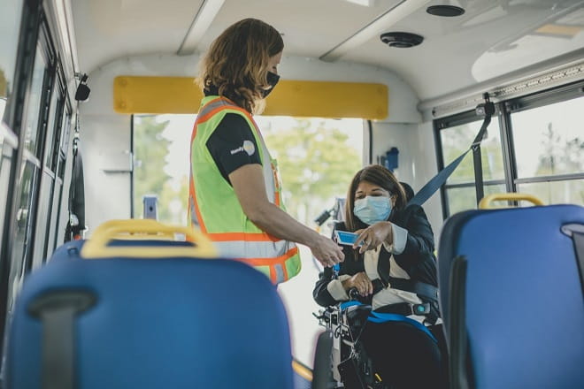 HandyDART operator assists customer with Compass Card