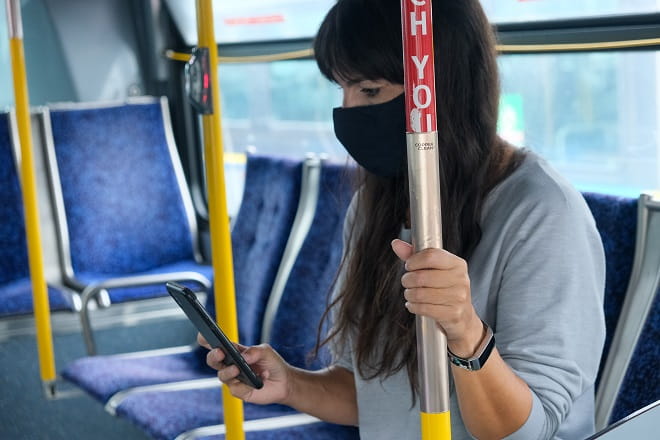 Copper hand rail on board TransLink use gets held by rider