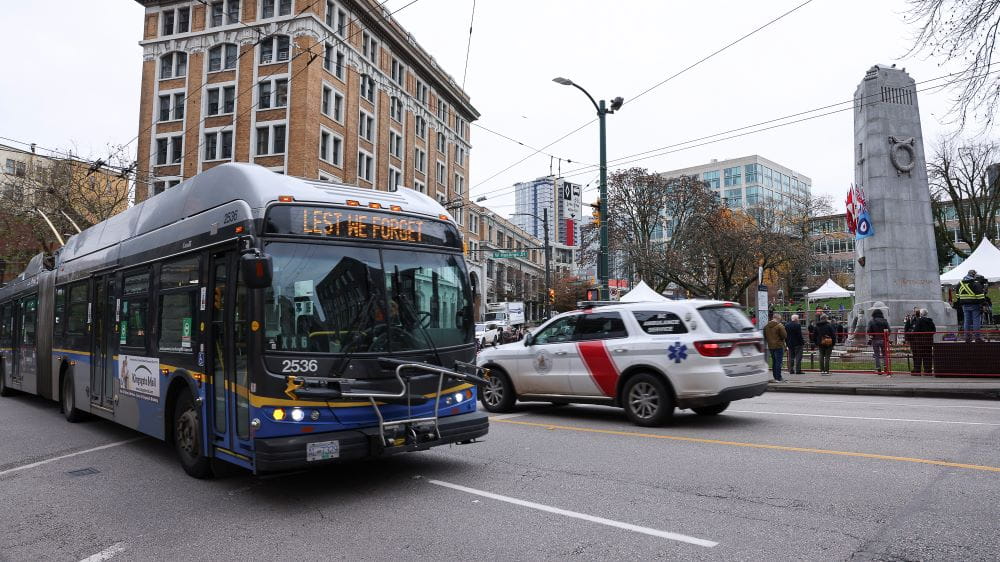 TransLink bus driving by Vancouver Cenotaph during Remembrance Day ceremony