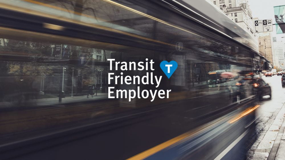 Blurred image of bus passing by with Transit-Friendly Employer logo in foreground.